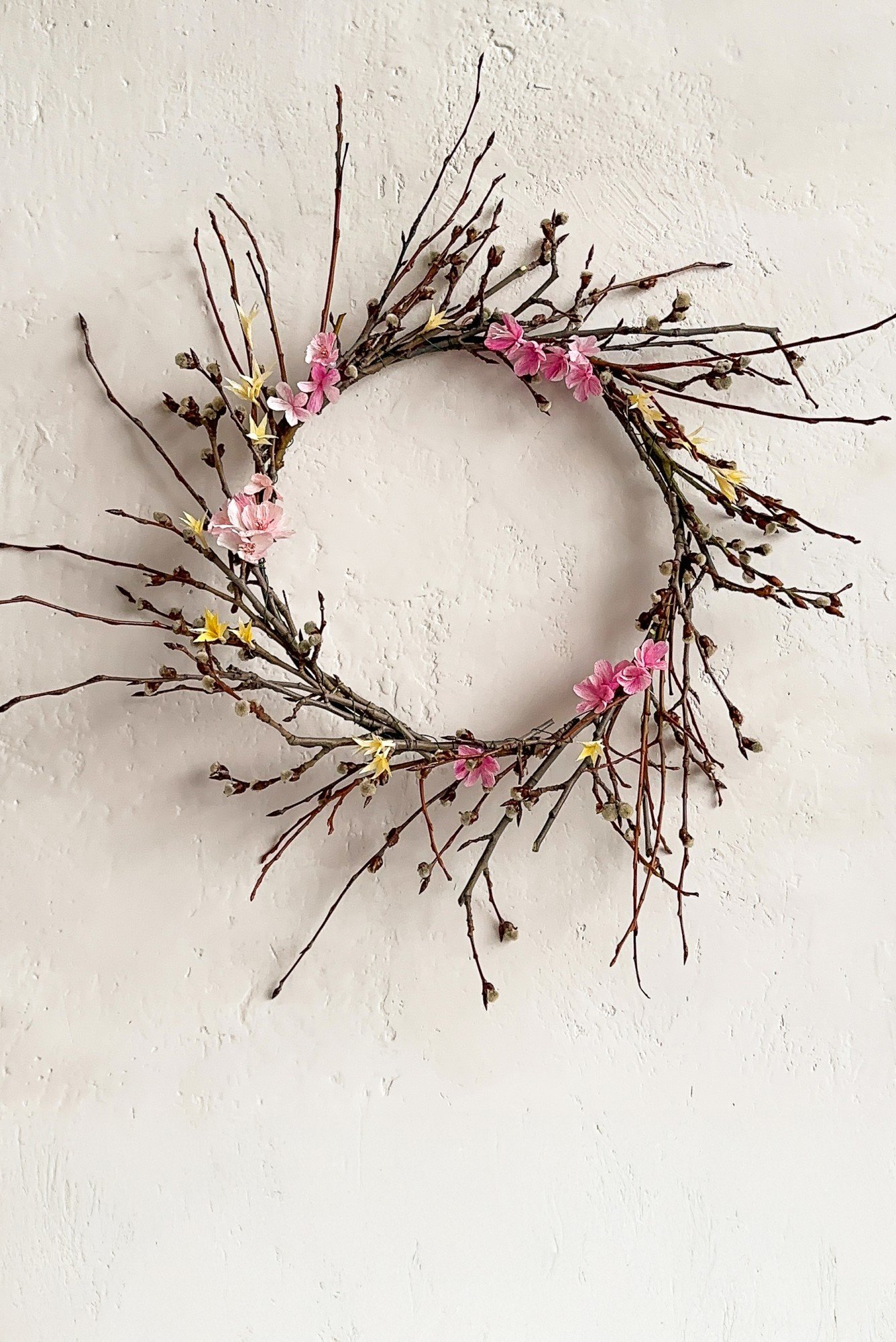 Tavaszi koszorú krepp-papír virágokkal díszítve