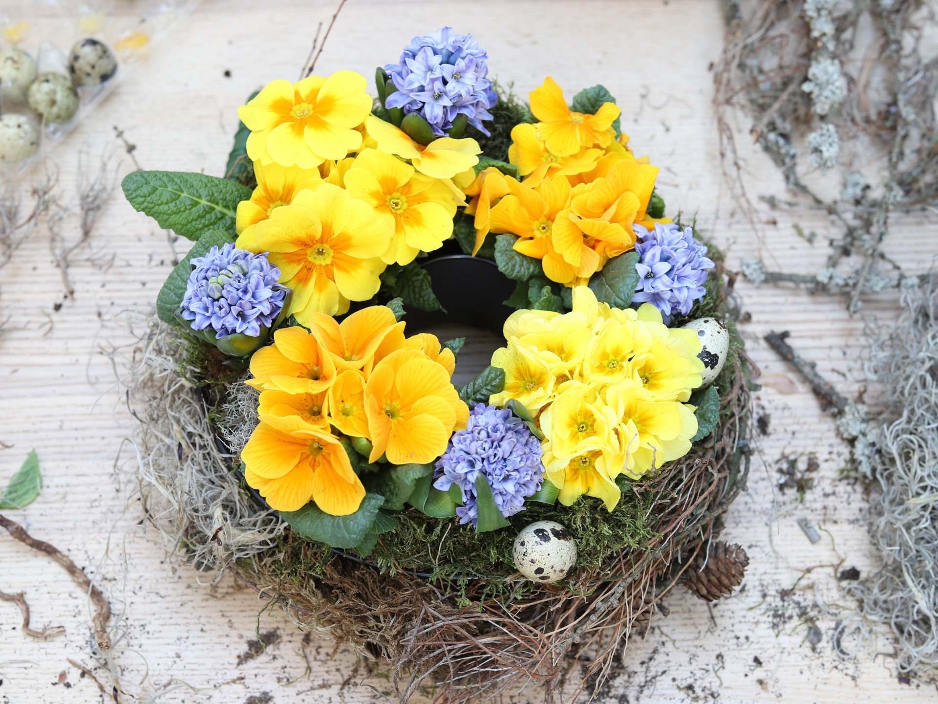 Színes tavaszi koszorú cserepes növényekből