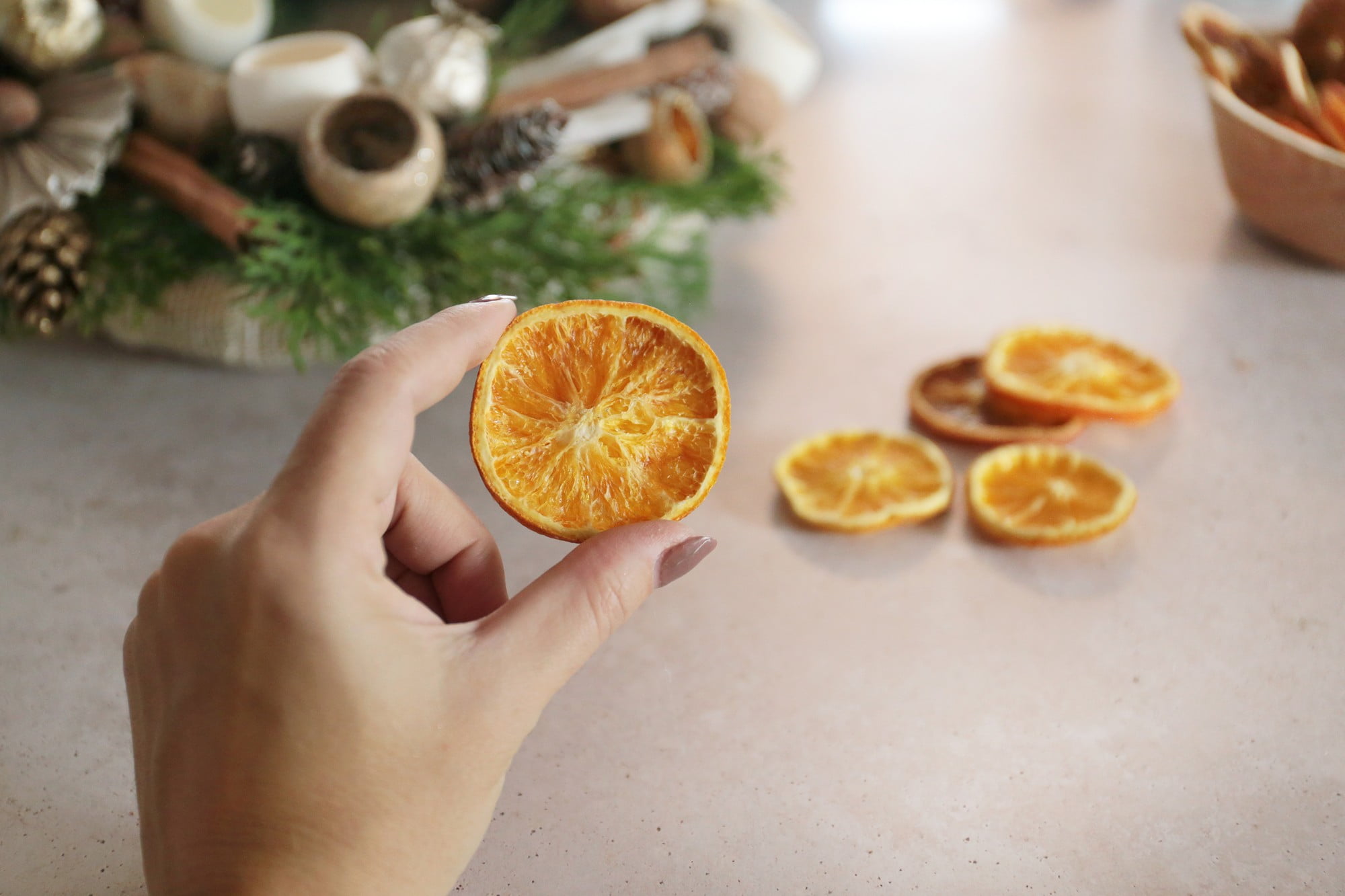 4. Adjunk hozzá fenyőtobozokat, fahéjrudakat és szárított narancsszeleteket!